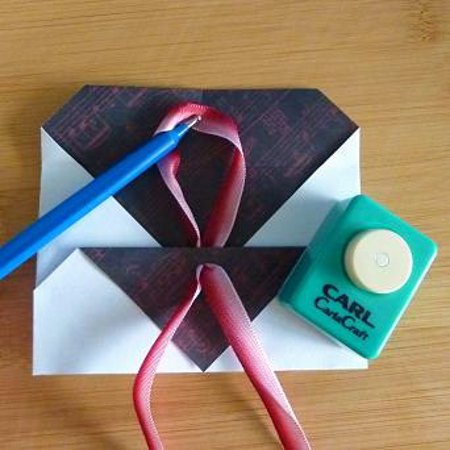 Threading ribbon through an envelope for fastening